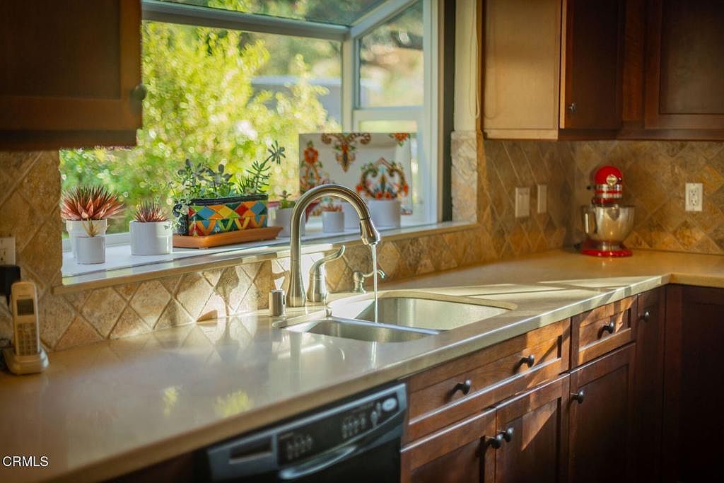Renovated kitchen with cherry cabinets and travertine backsplash